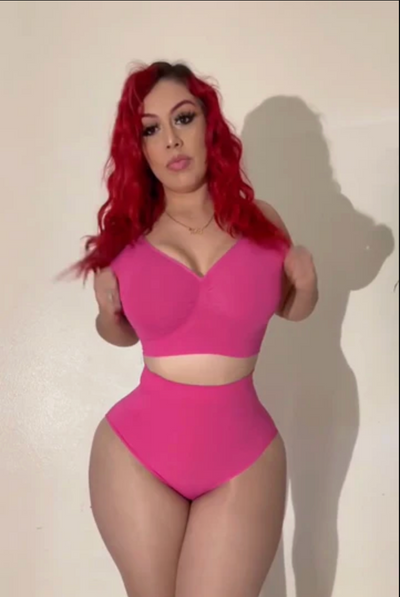 Person wearing a pink swimsuit against a plain background