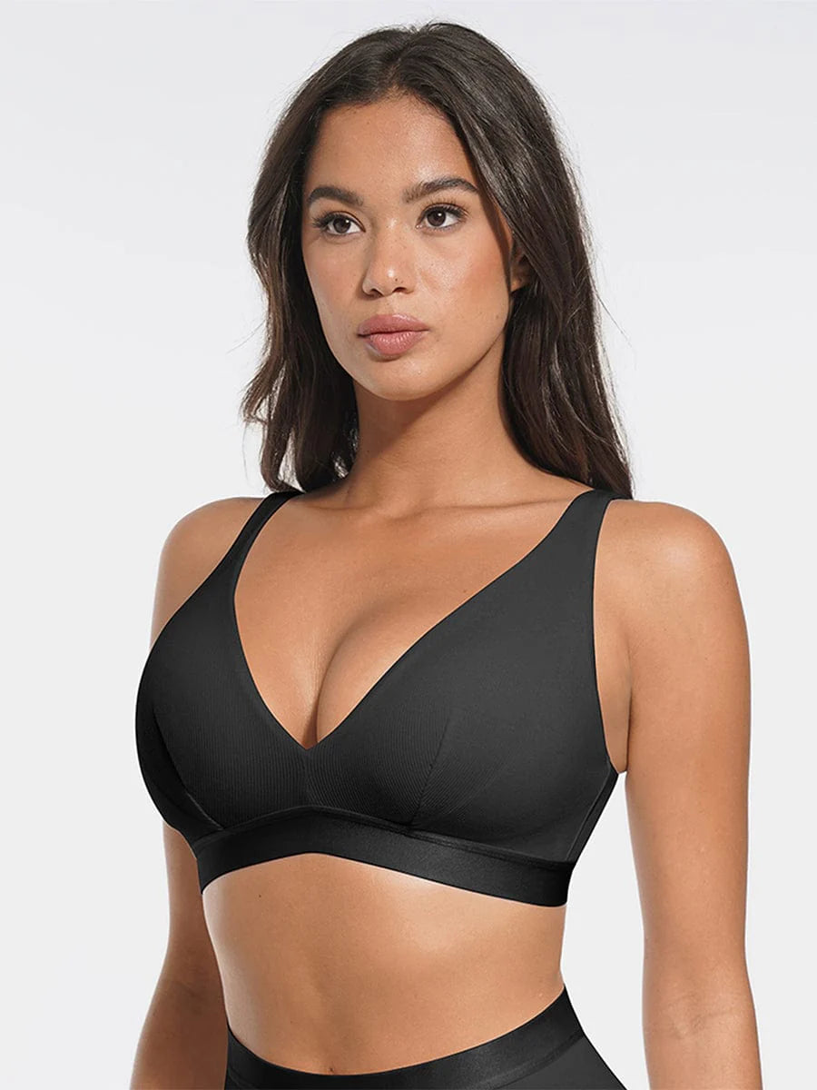 Woman wearing a black sports bra against a white background